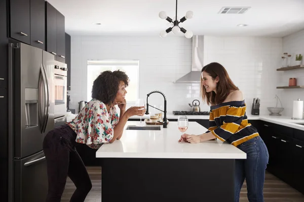 Dos Amigas Bebiendo Vino Casa Pie Junto Isla Cocina —  Fotos de Stock