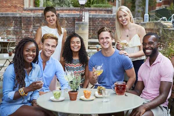 Retrato Amigos Sentados Mesa Pub Garden Disfrutando Bebida Juntos — Foto de Stock