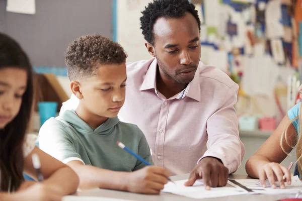 Mannelijke Leraar Werken Met Schooljongen Bij Bureau — Stockfoto