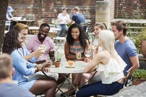 Amigos Sentados Mesa Pub Garden Disfrutando Bebida Juntos — Foto de Stock