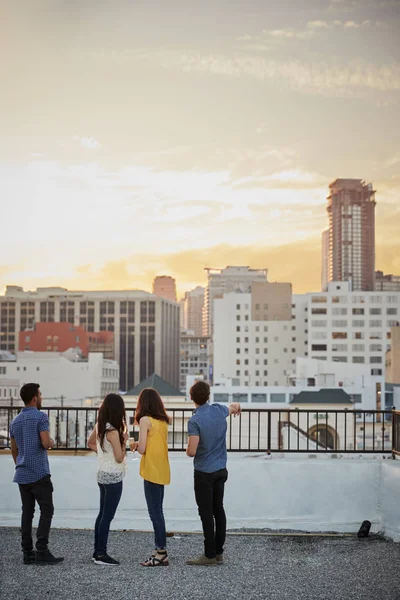 Achteraanzicht Van Vrienden Dakterras Uit Stad Skyline Kijken Naar Zonsondergang — Stockfoto