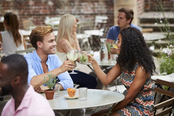 夫妇坐在桌上的酒吧花园享受饮料一起 — 图库照片