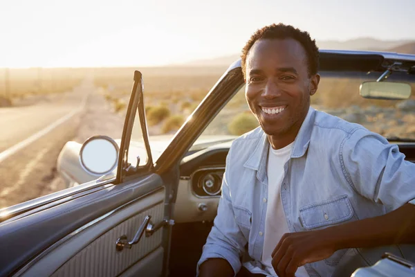 Man Enjoying Road Trip In Open Top Classic Car