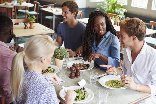 Grupo Amigos Sentados Mesa Restaurante Disfrutando Comida Juntos —  Fotos de Stock
