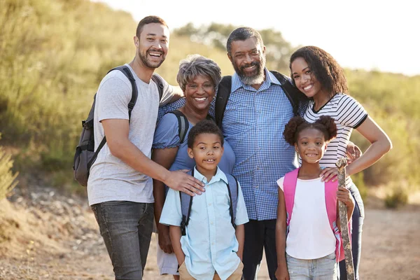 Multi Generation Family Wearing Backpacks Hiking Countryside Together — Stock Photo, Image