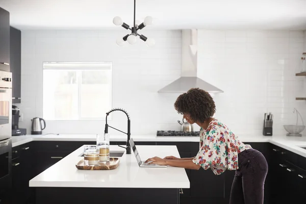 Mujer Casa Pie Isla Cocina Mientras Que Uso Ordenador Portátil —  Fotos de Stock