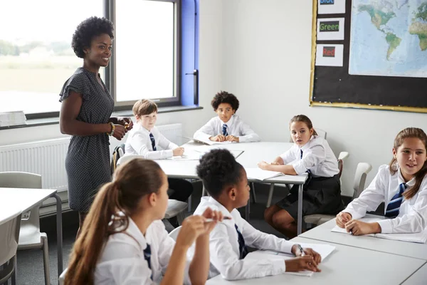 Oberstufenlehrerin Hilft Schülern Uniform Die Unterricht Tischen Sitzen — Stockfoto