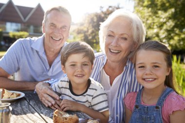Portrait Of Grandparents With Grandchildren Enjoying Outdoor Summer Snack At Cafe clipart