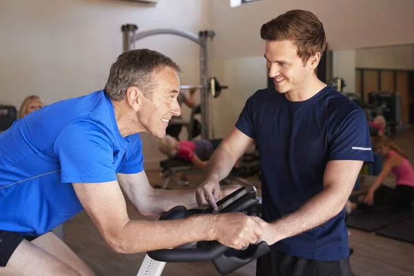 Senior Man Utövar Cykling Maskin Uppmuntras Personlig Tränare Gymmet — Stockfoto