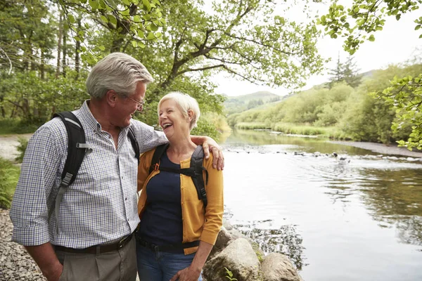 Seniorenpaar Wandert Auf Pfad Durch Fluss Seengebiet — Stockfoto