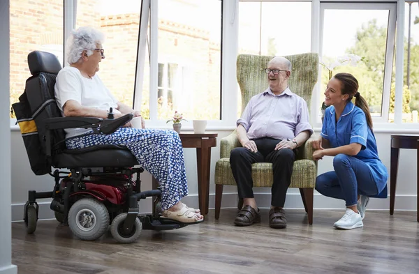 Mannelijke Vrouwelijke Bewoners Stoel Zitten Praten Met Verpleegkundige Bejaardentehuis — Stockfoto