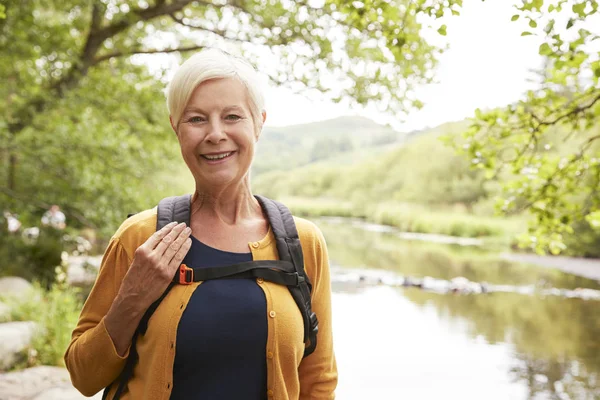 英国湖水地方の川でパスに沿ってハイキングを年配の女性の肖像画 — ストック写真