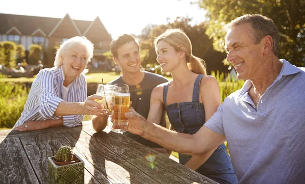 夏の屋外を楽しむ大人の子孫を持つ親は パブで飲む — ストック写真