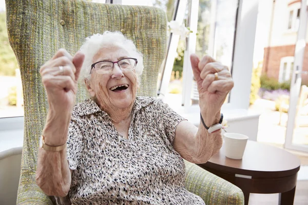 在退休之家休息室坐在椅子上的兴奋的高级妇女的肖像 — 图库照片