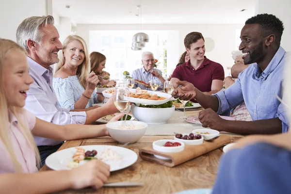 Mehrgenerationenfamilie Und Freunde Sitzen Tisch Und Essen Essen Mit Getränken — Stockfoto