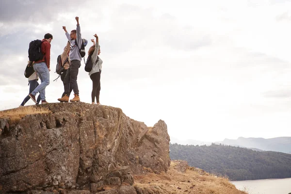 ハイキング中に 山の頂上で空気の腕と応援する幸せの つの若い大人のお友達のグループ — ストック写真