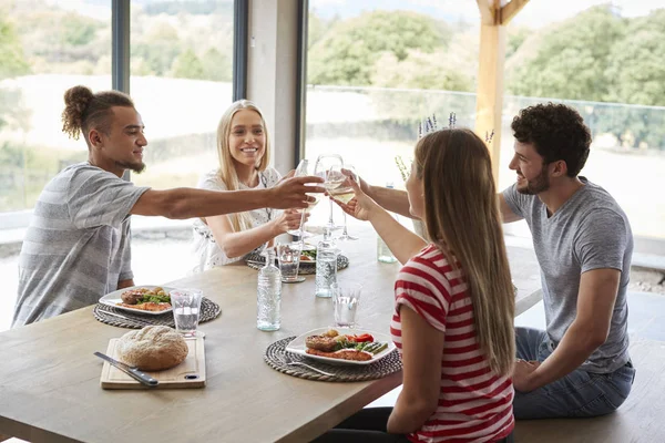 Quatro Jovens Amigos Adultos Comemorando Jantar Levantando Seus Copos Vinho — Fotografia de Stock