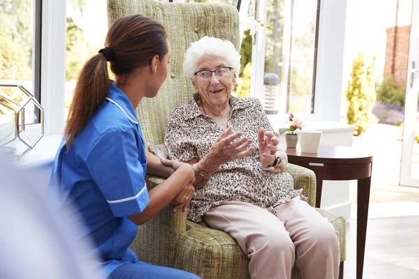 Senior Vrouw Zitten Stoel Praten Met Verpleegkundige Bejaardentehuis — Stockfoto