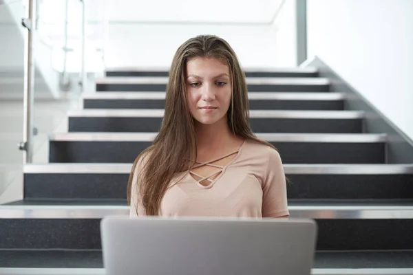 坐在楼梯上使用笔记本电脑的女高中生 — 图库照片