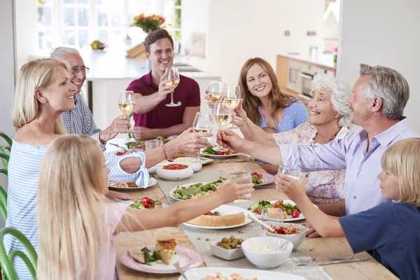 Mehrgenerationenfamilie Und Freunde Sitzen Tisch Und Essen Essen Mit Getränken — Stockfoto