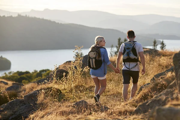 Achteraanzicht Van Paar Lopen Bovenop Heuvel Wandeling Door Platteland Lake — Stockfoto