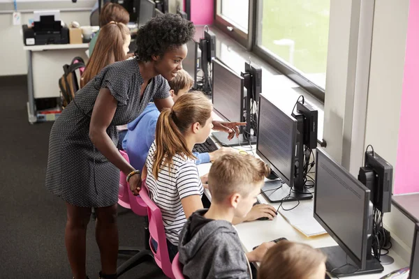 教师帮助在计算机课堂上做屏幕的高中生女生队伍 — 图库照片