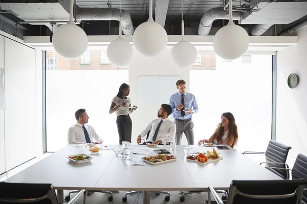 Hombres Negocios Mujeres Negocios Reúnen Moderna Sala Juntas Durante Almuerzo —  Fotos de Stock