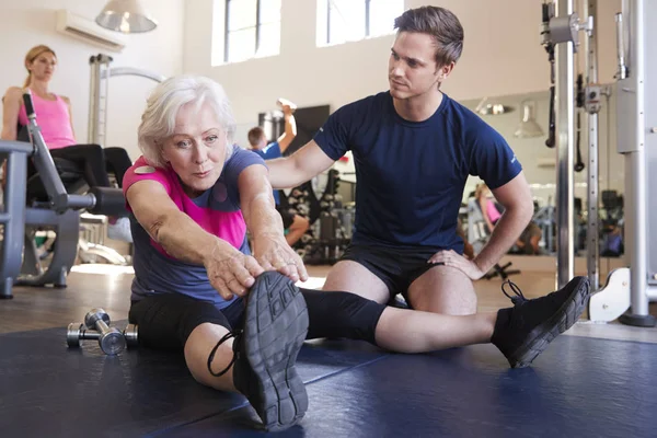 Seniorin Trainiert Fitnessstudio Und Wird Von Personal Trainer Ermutigt — Stockfoto