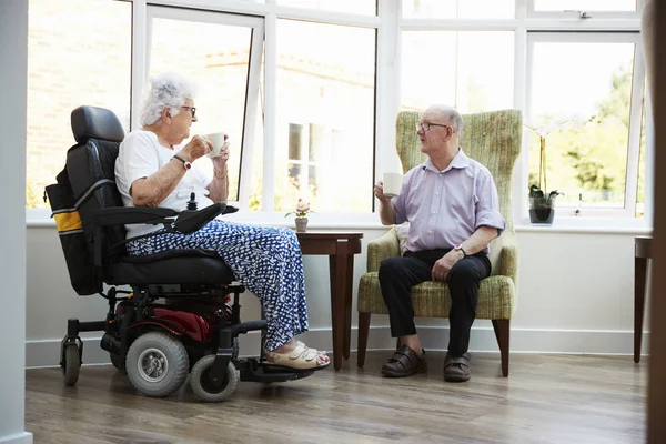 坐在椅子上 在退休回家时说话的男性和女性居民 — 图库照片