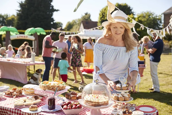 裏庭のピクニックで甘いケーキやデザートとテーブル 人々は食べ物を楽しむ — ストック写真