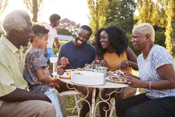 Μαύρο Πολλαπλών Γενιάς Οικογένεια Τρώει Ένα Τραπέζι Στον Κήπο — Φωτογραφία Αρχείου