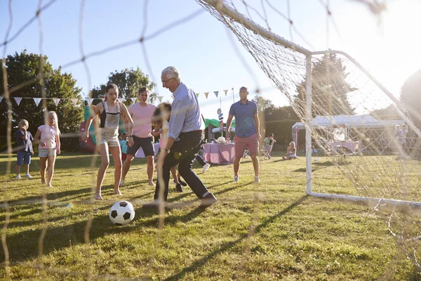 サマーガーデンヤードで父と祖父とサッカーの試合をする子供たち — ストック写真