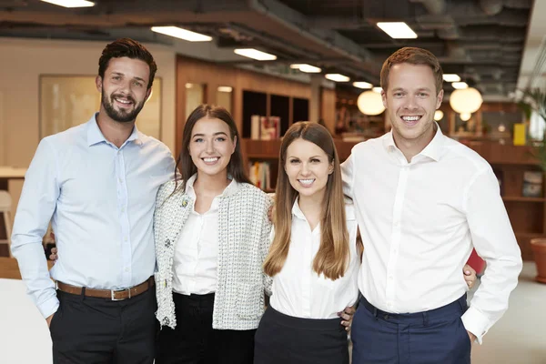 Portrait Of Young Businessmen And Businesswomen Standing In Modern Office At Graduate Recruitment Assessment Day