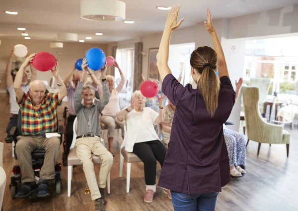 Carer Leading Group Seniors Fitness Class Retirement Home — стоковое фото