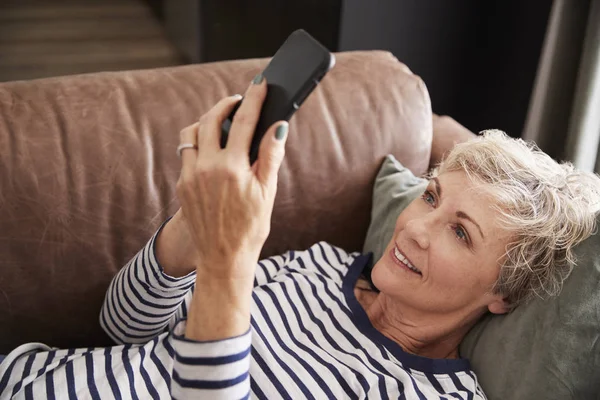 Starší Žena Leží Gauči Pomocí Telefonu Zvýšená Zavřít Nahoru — Stock fotografie