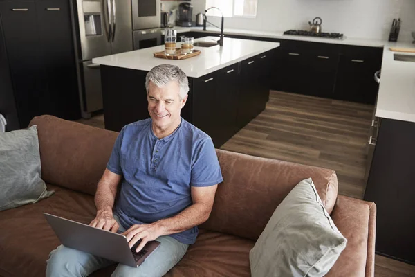 Älterer Weißer Mann Sitzt Auf Sofa Mit Laptop Erhöhter Blick — Stockfoto