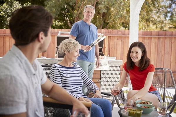 Ανώτερος Ζευγάρι Και Ενήλικα Παιδιά Barbecuing Έξω Από Σπίτι — Φωτογραφία Αρχείου