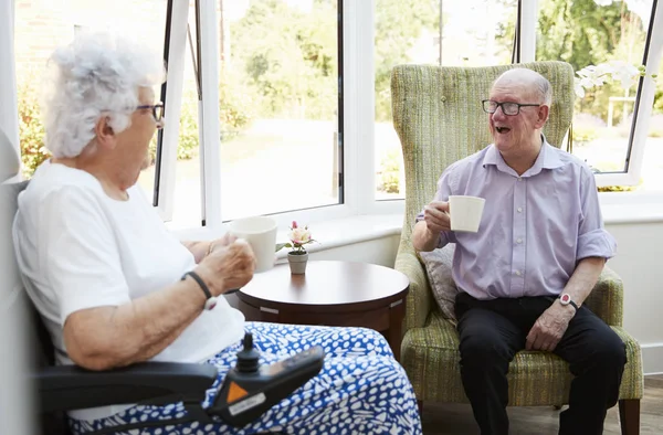 坐在椅子上 在退休回家时说话的男性和女性居民 — 图库照片