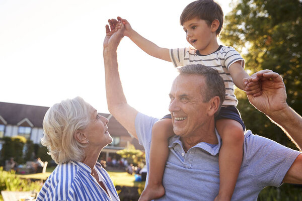 Grandparents Giving Grandson Ride Shoulders Summer Park Flaring Sun Stock Image