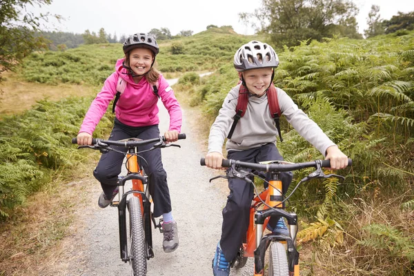 Duas Crianças Andando Bicicleta Montanha Caminho Campo Rindo Vista Frontal — Fotografia de Stock