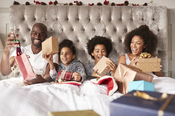 Leende Lyckliga Afroamerikanska Familjen Med Barnen Öppna Presenter Sängen Juldagsmorgonen — Stockfoto