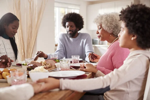 多世代混血家族手を繋いでいると彼らの日曜日の夕食の選択と集中を食べる前に猶予を言っ — ストック写真