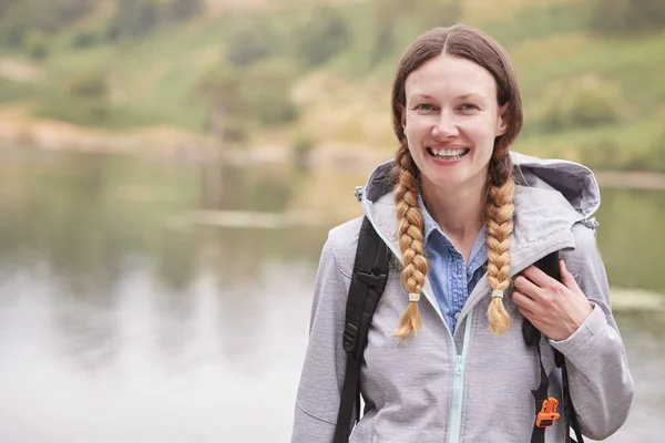 キャンプ休日に笑って 肖像画湖そばに立っている若い成人女性 — ストック写真