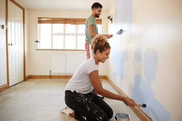 カップルの新しい家で部屋を飾ること 一緒に壁を塗る — ストック写真