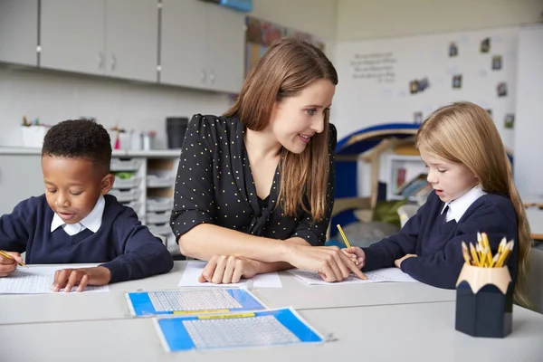 Lehrerin Sitzt Zwischen Zwei Grundschulkindern Einem Tisch Einem Klassenzimmer Und — Stockfoto
