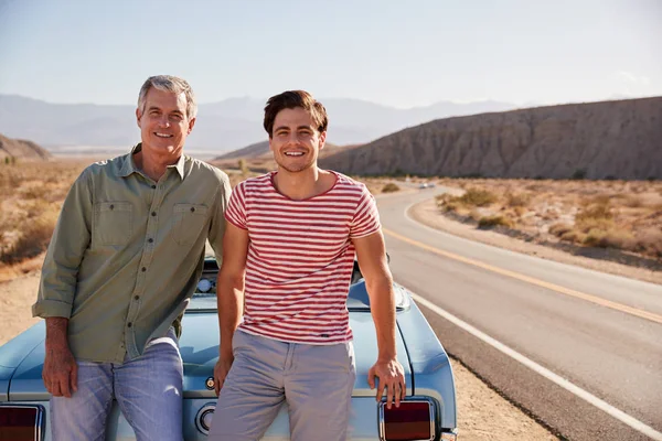 自分の車にもたれて道旅行に父と大人の息子 — ストック写真