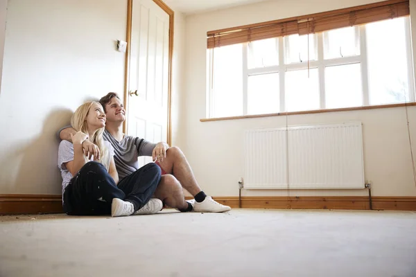 Ζευγάρι Κάθεται Στο Πάτωμα Στο Άδειο Δωμάτιο Του Νέου Σπιτιού — Φωτογραφία Αρχείου