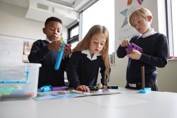 Három Általános Iskolás Gyermekek Dolgoznak Együtt Játék Építőkövei Egy Osztályteremben — Stock Fotó