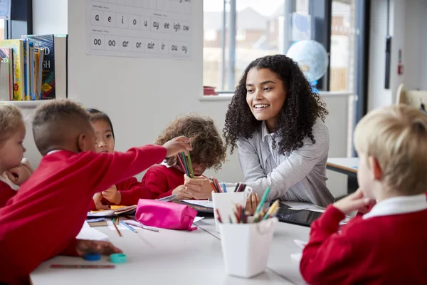 Μπροστινή Όψη Του Χαμογελαστή Θηλυκού Δασκάλου Νηπιακών Σχολείων Που Κάθονται — Φωτογραφία Αρχείου