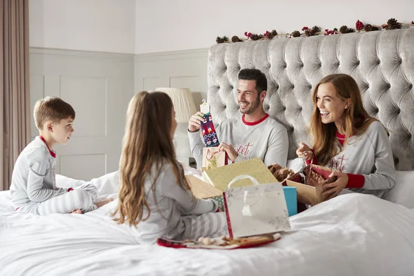Föräldrar Öppna Presenter Från Barn När Sitter Sängen Utbyta Närvarande — Stockfoto